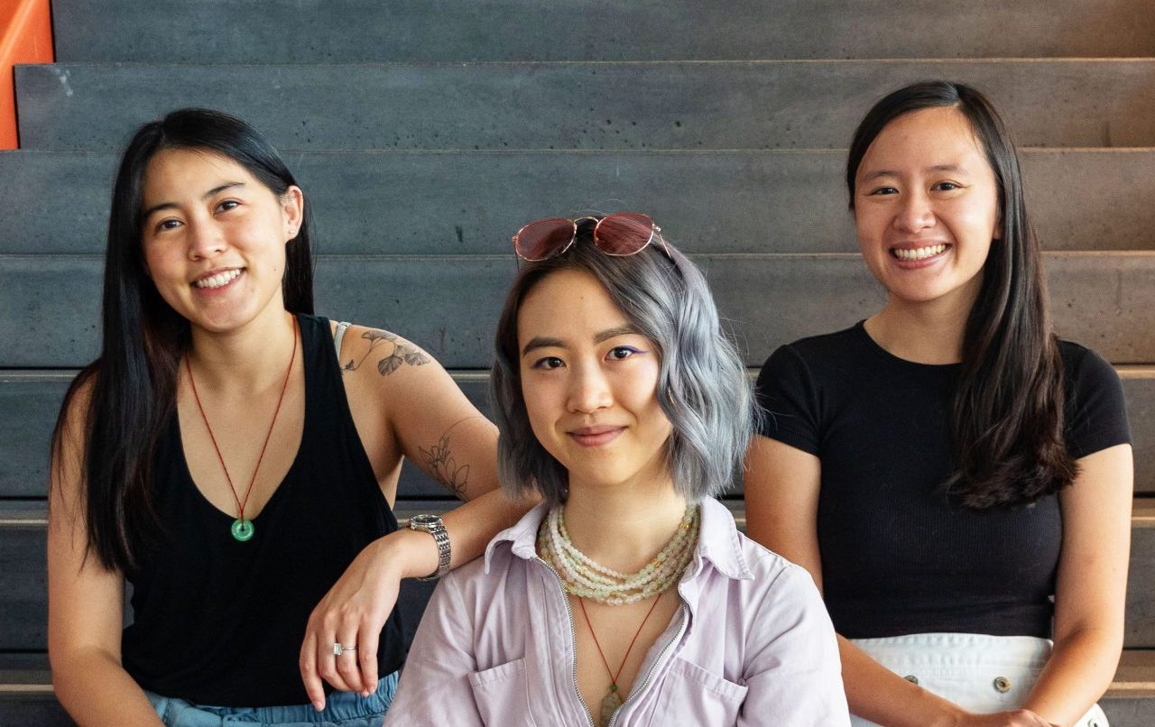 Asian Joy members posting at the bottom of stairs. From left to right: Ina Liu, Isabel Lu, Sophie To